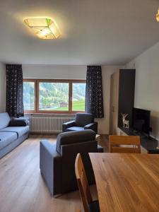 a living room with a couch and a table at Villa Maria - Appartamento vista montagna in Moena