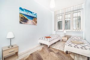 a living room with two beds and a window at Baltic Plaza Gdynia - MAXIMAL in Gdynia