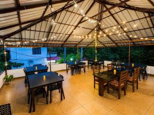 an outdoor patio with tables and chairs and lights at Chilanka Lake View Resort in Alleppey