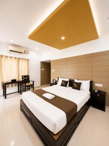 a bedroom with a large bed and a desk at Chilanka Lake View Resort in Alleppey