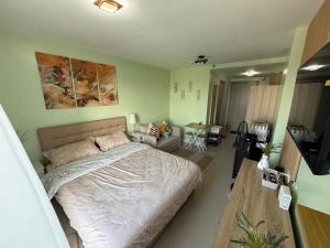 a bedroom with a large bed and a living room at D Avenue Studio in Iloilo City +3 photos