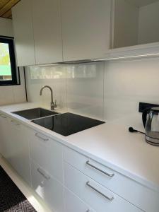 a kitchen with a sink and white cabinets at Kargevärava kämping in Kapra