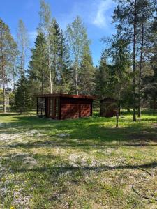 a cabin in the middle of a field with trees at Kargevärava kämping in Kapra