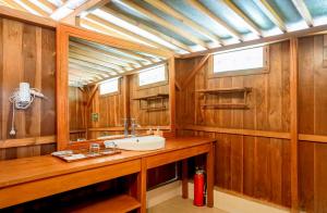 a bathroom with a sink and wood paneled walls at Leebong Island Resort in Leebong