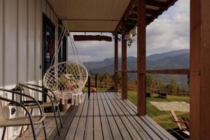 a porch with chairs and a swing on a house at Lehit slavsko in Slavske