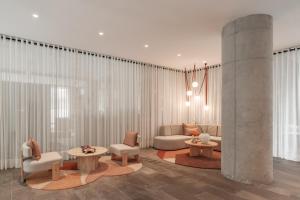 a living room with couches and tables and curtains at Nomu Mexico City by Lumina in Mexico City