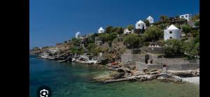 a group of houses on a hill next to the water at Villa Vassia in Koundouros