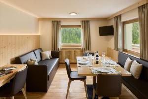 a dining room with a table and a couch at Ciasa Col Cuch in La Villa