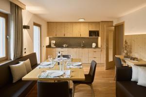 a dining room with a table and a kitchen at Ciasa Col Cuch in La Villa