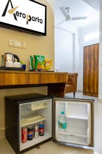 an open refrigerator with its door open in a kitchen at Hotel Aeroporto in New Delhi