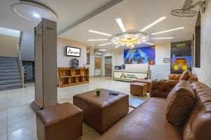 a large living room with a couch and chairs at Hotel Aeroporto in New Delhi