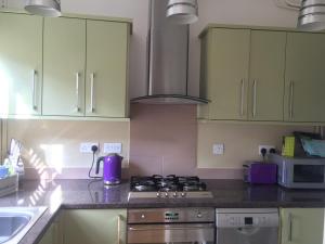 a kitchen with a stove top oven next to a sink at Hillside Cottage in Wirksworth
