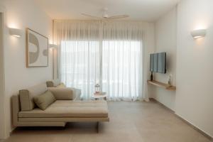 a living room with a couch and a television at Aktis Seaside Living in Iraklitsa