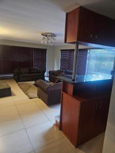 a living room with two couches and a living room with a couch at NAMOLEKA House- Bloemfontein in Bloemfontein