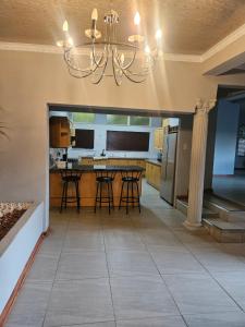 a kitchen with a table and chairs and a chandelier at NAMOLEKA House- Bloemfontein in Bloemfontein