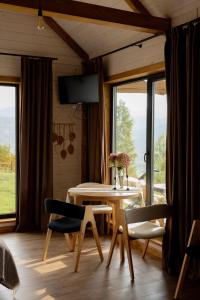 a living room with a table and chairs and windows at Lehit slavsko in Slavske
