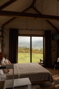a bedroom with a bed and a large window at Lehit slavsko in Slavske
