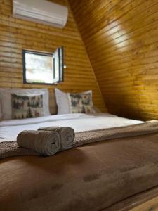 a bed in a wooden room with towels on it at DnD Mountain Escape in Holbav +45 photos