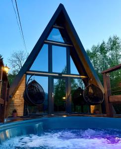 a house with a swimming pool in front of a window at DnD Mountain Escape in Holbav