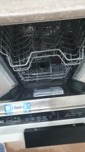 an open dishwasher with a dvd player in it at NiC Apartment in Râmnicu Vâlcea