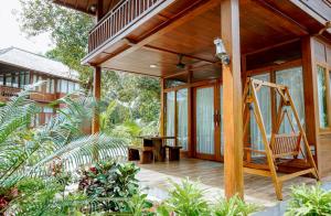 a porch of a house with a swing at Leebong Island Resort in Leebong