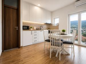 a kitchen and dining room with a table and chairs at Apartments Miš in Trebinje