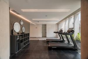a gym with treadmills and mirrors in a room at Nomu Mexico City by Lumina in Mexico City