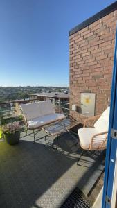 a patio with two chairs and a table on a roof at Spacious apartment with amazing views in Sandnes