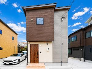 a house with a wooden door and a car at HOTEL StayLuck KOTOHIRA - 琴平駅徒歩4分 in Kotohira