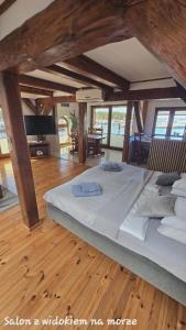 a large bed in a room with wooden floors at Syrenka Apartamenty in Ustka