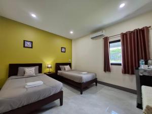 a hotel room with two beds and a window at สายป่าน เฮ้าส์ แพร่ in Ban San Pa Yae +37 photos