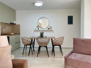 a dining room with a table with chairs and a mirror at Nikol's central suite 2 in Nea Peramos