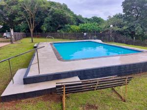 a swimming pool with a bench in a yard at Anchors Aweigh in Hibberdene
