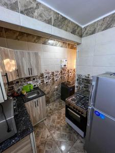 a small kitchen with a stove and a refrigerator at عماره in Sheikh Zayed