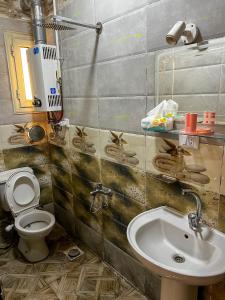 a bathroom with a toilet and a sink at عماره in Sheikh Zayed