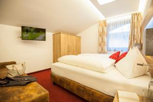 ein Schlafzimmer mit einem großen weißen Bett und einem Fenster in der Unterkunft Landhaus & Appartementhaus Haussteiner in Dorfgastein