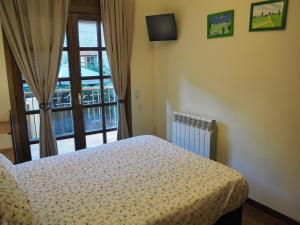 ヴィラヨンガ・デ・テルにあるWatching Vilallonga de Terのベッドルーム1室(ベッド1台、大きな窓付)