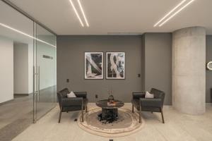 a lobby with two chairs and a table in a room at Nomu Mexico City by Lumina in Mexico City