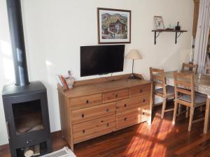 sala de estar con TV en la parte superior de una cómoda de madera en Watching Vilallonga de Ter, en Vilallonga de Ter