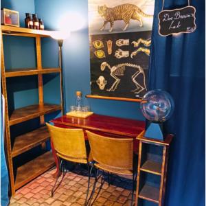 a room with a table and chairs and a blue wall at Emporium in Lobbes