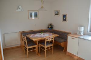eine Küche mit einem Holztisch, Stühlen und einer Theke in der Unterkunft Wastlhof in Mals im Vinschgau