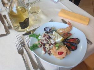 a plate of food with shrimp and vegetables on a table at Grazia Hotel in Sperlonga