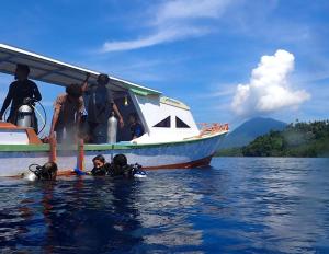 a group of people on a boat in the water at 4 Sisters Divers in Bunaken