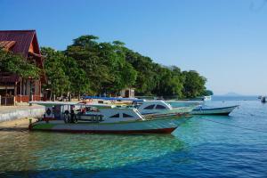 a group of boats docked at a dock in the water at 4 Sisters Divers in Bunaken