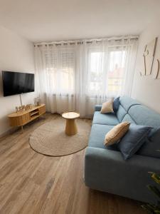 a living room with a blue couch and a tv at Ferienwohnung Rehn 2 in Bad Kissingen