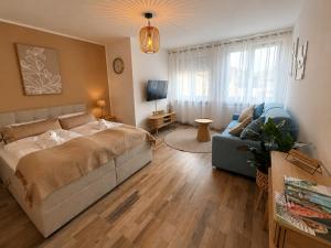 a bedroom with a bed and a couch and a living room at Ferienwohnung Rehn 2 in Bad Kissingen