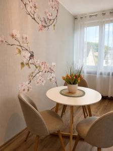 a table and chairs in a room with flowers on the wall at Ferienwohnung Rehn 2 in Bad Kissingen