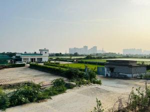 an empty parking lot with buildings in the background at Mangalm Farm & Resort in Greater Noida