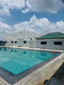 a large swimming pool in front of a building at Mangalm Farm & Resort in Greater Noida
