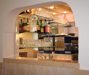 a bar with glasses on the shelves in a restaurant at Grazia Hotel in Sperlonga